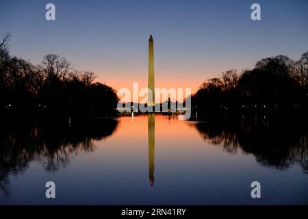 Washington Monument Reflecting Pool Washington DC // WASHINGTON DC – das Washington Monument spiegelt sich bei Sonnenaufgang im ruhigen Wasser des Reflecting Pools wider. Das Licht am frühen Morgen taucht die National Mall in ein warmes Licht, das den berühmten Obelisken hervorhebt und eine ruhige und malerische Szene schafft. Das Washington Monument, eines der bekanntesten Wahrzeichen der Vereinigten Staaten, ist eine Hommage an den ersten Präsidenten der USA, George Washington. Stockfoto