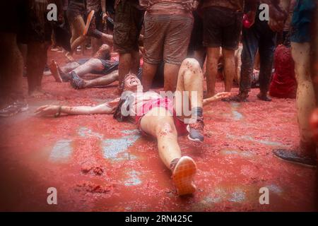 Valencia, Spanien. 30. August 2023. Während des Tomatina-Festivals ernährt sich ein Tourist mit zerstoßenen Tomaten. Ein weiteres Jahr, wie jeden letzten Mittwoch des Monats August, wurde La Tomatina in der valencianischen Stadt Buñol in Spanien gefeiert. Ein fest, das seit mehr als 50 Jahren stattfindet und an eine Meinungsverschiedenheit zwischen den Landwirten erinnert, die mit einem Tomatenkampf endete und das traditionelle Festival begründete. (Foto: David Canales/SOPA Images/SIPA USA) Credit: SIPA USA/Alamy Live News Stockfoto