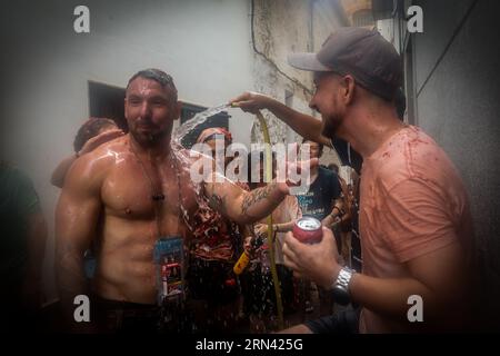 Valencia, Spanien. 30. August 2023. Ein Mann versucht, zerstoßene Tomaten von einem Teilnehmer am tomatina-Festival zu entfernen. Ein weiteres Jahr, wie jeden letzten Mittwoch des Monats August, wurde La Tomatina in der valencianischen Stadt Buñol in Spanien gefeiert. Ein fest, das seit mehr als 50 Jahren stattfindet und an eine Meinungsverschiedenheit zwischen den Landwirten erinnert, die mit einem Tomatenkampf endete und das traditionelle Festival begründete. (Foto: David Canales/SOPA Images/SIPA USA) Credit: SIPA USA/Alamy Live News Stockfoto