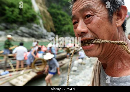 AKTUELLES ZEITGESCHEHEN Treideln - Bootsschlepper in Wuhan, China (150503) -- WUHAN, 3. Mai 2015 -- Foto aufgenommen am 30. April 2015 zeigt den Bootstracker Wu Qibiao, der die Schleppleine nach Erreichen des Endes entlang des Shennongxi-Flusses in der Provinz Badong in der zentralchinesischen Provinz Hubei nagt. Bereits in den 1950er Jahren waren die Einheimischen stark auf Bootsschlepper angewiesen, da der Verkehr recht begrenzt war. Da Shennongxi keine Zufahrt zu den Straßen hat, ist es der einzige Weg hinein und raus, und daher war es damals sehr beliebt, ein Fährtensucher zu sein. Ende der 1980er Jahre, mit neuen Straßen in den Bergen und der Entwicklung des Tourismus, viele davon Stockfoto