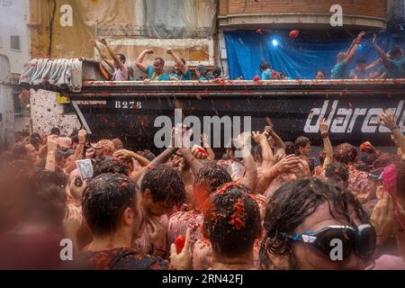 Valencia, Spanien. 30. August 2023. Dutzende von Touristen heben ihre Hände, während sie Tomaten von den LKWs der Veranstaltungsorganisation während des Tomatina Festivals werfen und auf sie geworfen werden. Ein weiteres Jahr, wie jeden letzten Mittwoch des Monats August, wurde La Tomatina in der valencianischen Stadt Buñol in Spanien gefeiert. Ein fest, das seit mehr als 50 Jahren stattfindet und an eine Meinungsverschiedenheit zwischen den Landwirten erinnert, die mit einem Tomatenkampf endete und das traditionelle Festival begründete. (Foto: David Canales/SOPA Images/SIPA USA) Credit: SIPA USA/Alamy Live News Stockfoto