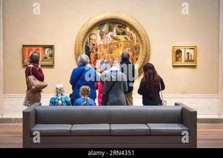 WASHINGTON, D.C., USA – Besucher bewundern Fra Angelico und Filippo Lippi's „Anbetung der Könige“ (ca. 1440-1460) in der National Gallery of Art Dieses Meisterwerk der Renaissance zieht Kunstliebhaber an, um seine komplizierten Details und seine religiöse Bedeutung zu betrachten. Stockfoto