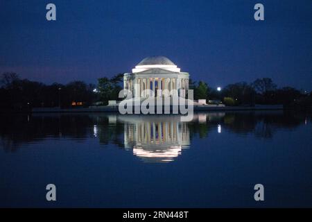 Thomas Jefferson Memorial Reflection at Night Washington DC // WASHINGTON, D.C., Vereinigte Staaten – das Thomas Jefferson Memorial spiegelt sich nachts im stillen Wasser des Tidal Basin wider. Das neoklassizistische Denkmal, das dem dritten Präsidenten der Vereinigten Staaten gewidmet ist, wird vor dem dunklen Himmel beleuchtet. Die gewölbte Struktur und das Spiegelbild bilden eine symmetrische Szene auf der National Mall. Stockfoto