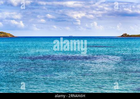 Türkisfarbenes Wasser, unbewohnte felsige Inseln am Horizont, kornische Karibik, St. Martins, Scilly-Inseln, Cornwall, England, Vereinigtes Königreich Stockfoto