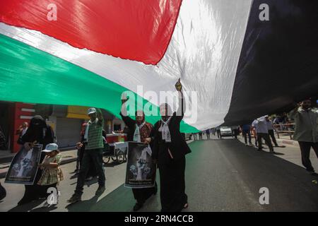 (150516) -- GAZA, 16. Mai 2015 -- Frauen laufen unter einer großen palästinensischen Flagge während eines marsches anlässlich des 67. Jahrestages der Nakba in Gaza-Stadt am 16. Mai 2015. Der Nakba, was Tag der Katastrophe bedeutet, ist der palästinensische Tag zum Gedenken an die Vertreibung nach dem arabisch-israelischen Krieg von 1948. ) MIDEAST-GAZA-NAKBA TAG WissamxNassar PUBLICATIONxNOTxINxCHN Gaza 16. Mai 2015 Frauen gehen unter einer großen PALÄSTINENSISCHEN Flagge während eines Marsches zum 67. Jahrestag der Nakba in Gaza-Stadt AM 16. Mai 2015 der Nakba bedeutete Tag der Katastrophe IST der PALÄSTINENSISCHE Tag zum Gedenken an die Stockfoto