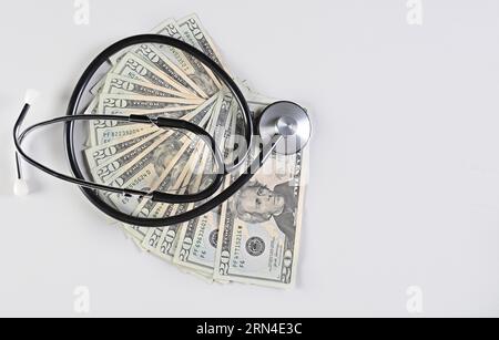 Medizinisches Stethoskop auf zwanzig Dollar Rechnungen isoliert, medizinische Gesundheit Kostenkonzept, Stethoskop und Geld. Stethoskop auf 1-Dollar-Scheinen isoliert Stockfoto