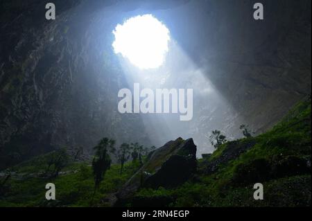 (150519) -- ENSHI, 19. Mai 2015 -- Sonnenlicht berührt die Pflanzen in einem Senkenloch im gebirgigen Xuanen County in der zentralchinesischen Provinz Hubei, 19. Mai 2015. Aufgrund der lokalen Karstlandschaft und des feuchten Klimas ist ein mehr als 290 Meter tiefer Sinkloch in Xuanen Heimat für verschiedene Pflanzen und Tiere geworden. Ein vollständiges und originelles Ökosystem wird im Loch gehalten, da es für Menschen schwer ist, reinzukommen. ) (zhs) CHINA-HUBEI-SINKHOLE-LANDSCHAFT (CN) SongxWen PUBLICATIONxNOTxINxCHN 150519 Enshi 19. Mai 2015 Sonnenlicht berührt die Pflanzen in einem Sinkhole im bergigen Xuanen County in Zentralchina S Hubei Stockfoto