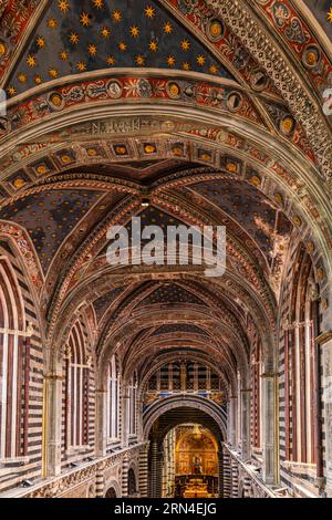 Blick auf das Innere der Kathedrale vom Himmelstor, Porta del Cielo, schwarz-weiß gestreifte Marmorsäulen und Rundbögen, Siena Stockfoto