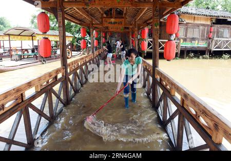 AKTUELLES ZEITGESCHEHEN Überschwemmungen im Südwesten Chinas (150520) -- GUILIN, 20. Mai 2015 -- Menschen versuchen, eine überflutete Holzbrücke in Guilin, Südchinas autonome Region Guangxi Zhuang, 20. Mai 2015, zu reinigen. Als mehrere Orte in Guangxi von starkem Regen heimgesucht wurden, gab das örtliche Hydrologie- und Wasserressourcenbüro am Mittwoch eine blaue Warnung vor Überschwemmungen aus. ) (zhs) CHINA-GUANGXI-FLUTWARNUNG (CN) LuxBoan PUBLICATIONxNOTxINxCHN Nachrichten aktuelle Ereignisse Überschwemmungen in Südwestchina 150520 Guilin 20. Mai 2015 Prominente versuchen, eine überflutete Holzbrücke in Guilin Südchina S Guangxi Zhuang Aut zu reinigen Stockfoto