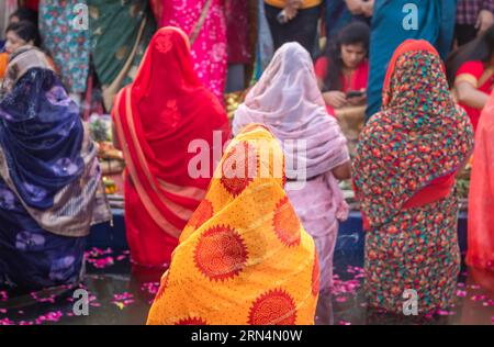 Frauen, die im Fluss stehen und für den sonnengott im Chhath-Festival beten Stockfoto
