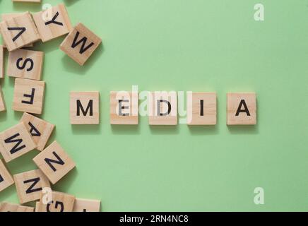 Textmedien auf Holzwürfeln auf grünem Hintergrund Stockfoto