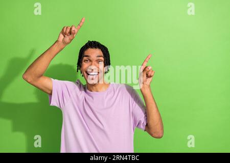 Foto von Youngster Guy Good Mood Regie Daumen Leere Platz Einkaufen Angebot Verkauf isolierte grüne Farbe Hintergrund Stockfoto