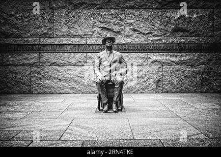 FDR-Skulptur, FDR Memorial, Washington, D.C. Schwarzweiß-Fotografie zeigt die Bronzestatue, die in einem Rollstuhl an einer Steinmauer mit Inschrift sitzt. Stockfoto