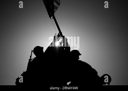 Die Sonne geht hinter eine Silhouette von Iwo Jima Memorial (Marine Corps Memorial) in Arlington, Virginia. Die große Bronzestatue basiert auf einer Fotografie von AP-Fotograf Joe Rosenthal der USA behaupten die Insel Iwo Jima im pazifischen Theater des zweiten Weltkrieges. Stockfoto