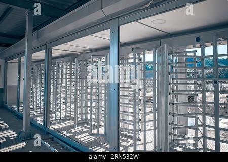 Neu gebautes Sicherheitstor für die Zugangskontrolle. Vorgefertigtes Sicherheitsdrehkreuz auf der Baustelle. Geschütztes Eingangstor Stockfoto