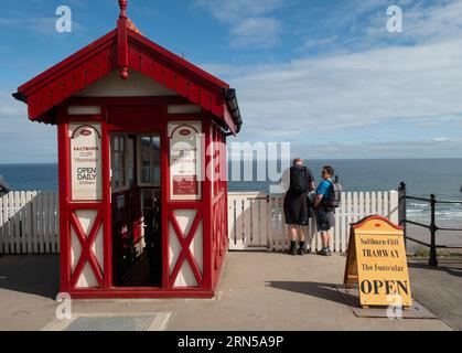 Die Bergstation der Saltburn Cliff Seilbahn wurde am Spätsommertag neu renoviert, mit einem Mann und einer Frau, die über die Klippe blicken Stockfoto