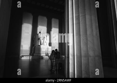 WASHINGTON DC, USA - Die große Statue in der Kammer des Lincoln Memorial Fang am frühen Morgen, goldenes Sonnenlicht bei Sonnenaufgang im Herbst (Herbst) Equinox. Das Lincoln Memorial liegt am westlichen Ende der reflektierenden Pool und Gesichter direkt im Osten. Die Statue ist tief in der Kammer und ist in der Regel weit außerhalb der Reichweite der direkten Sonneneinstrahlung. Stockfoto