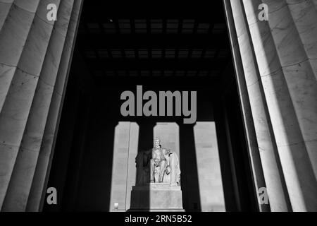 WASHINGTON DC, USA - Die große Statue in der Kammer des Lincoln Memorial Fang am frühen Morgen, goldenes Sonnenlicht bei Sonnenaufgang im Herbst (Herbst) Equinox. Das Lincoln Memorial liegt am westlichen Ende der reflektierenden Pool und Gesichter direkt im Osten. Die Statue ist tief in der Kammer und ist in der Regel weit außerhalb der Reichweite der direkten Sonneneinstrahlung. Stockfoto