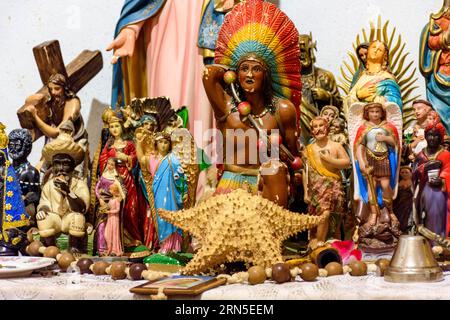 Altar mit mehreren Bildern von Heiligen, Wesenheiten afrikanischer Herkunft wie Umbanda und Candomble und Alltagsgegenstände in einem gut Stockfoto