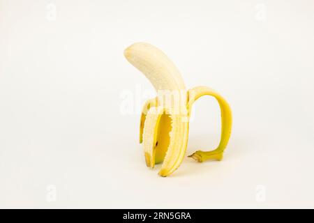 Halb geschälte Banane, Studioaufnahme, weißer Hintergrund, gesunde Ernährung Stockfoto