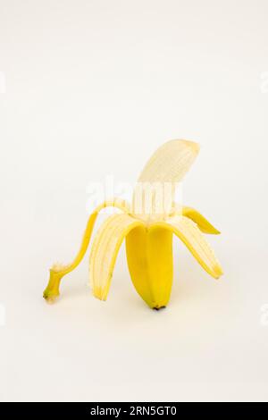 Halb geschälte Banane, Studioaufnahme, weißer Hintergrund, gesunde Ernährung Stockfoto