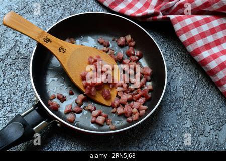 Gebratene Speckwürfel in Pfanne, Speck Stockfoto