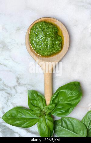 Pesto in Holzlöffel und Basilikum, Nudelsoße Stockfoto