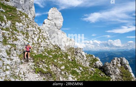 Bergsteiger auf einem Höhenweg, über die Hackenkoepfe, hinter Gipfel, Scheffauer, felsige Berge des Kaisergebirges, Wilder Kaiser, Kitzbühler Stockfoto