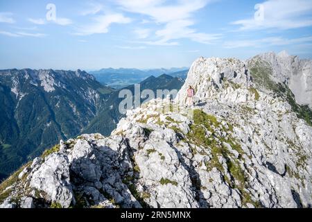 Bergsteiger auf einem Höhenweg, über die Hackenkoepfe, hinter Gipfel, Scheffauer, felsige Berge des Kaisergebirges, Wilder Kaiser, Kitzbühler Stockfoto