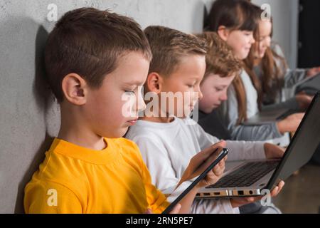 Kinder, die elektronische Geräte verwenden Stockfoto