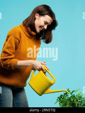 Frau mit mittlerer Schussaufnahme und Gießkannne Stockfoto