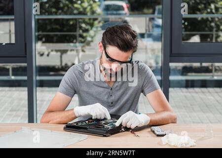 Junger Techniker, der Computerwerkstatt repariert Stockfoto