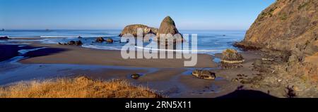 Silhouetten von Felsformationen bei Sonnenuntergang am Cannon Beach, Oregon, USA Stockfoto