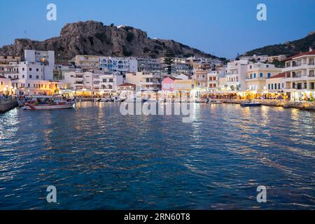 Griechenland, Dodekanesen, Karpathos, die beleuchtete Hafenstadt Pigadia am Abend Stockfoto