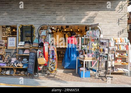 Junge Frau in traditionellem Hanbok, die in einem Souvenirladen in der Nähe des Dorfes Bukchon Hanok, Jongno-gu, Seoul steht Stockfoto