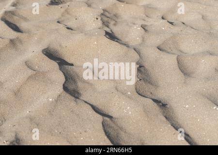 Sand am Strand als Hintergrund. Blick von oben, Nahaufnahme des Sandmusters eines Strandes Stockfoto