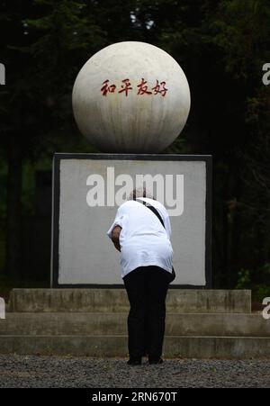 Ein japanischer Bürger, der während des Zweiten Weltkriegs von Chinesen adoptiert wurde, trauert um Adoptiveltern vor einem Grab auf einem Friedhof, um Adoptiveltern in Fangzheng County in der Nähe von Harbin, der Hauptstadt der nordöstlichen Provinz Heilongjiang, am 13. Juli 2015 zu gedenken. Eine Gruppe von 54 japanischen Staatsbürgern, die alle heute Waisen sind, besuchte am Montag die Gräber ihrer adoptiven chinesischen Eltern hier. Während des voreiligen Rückzugs am Ende des Zweiten Weltkriegs 1945 von ihren Eltern verlassen, wurden die Waisen, die heute über 70 Jahre alt sind, von den sehr chinesischen Bewohnern der Nordstaaten aufgenommen und aufgezogen Stockfoto