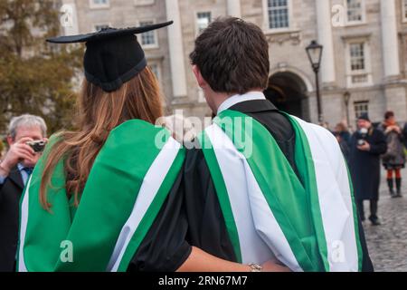 Die Absolventen posieren für Familienfotos im Trinity College am Abschlusstag. Trinity College, Dublin, Irland Stockfoto