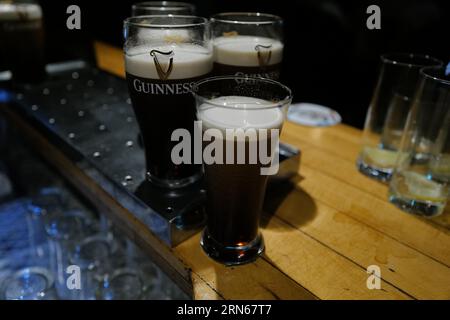 Pints und ein Glas Guinness Stout auf einem Serviertisch in einem Pub in der Nacht. Temple Bar, Dublin, Irland Stockfoto