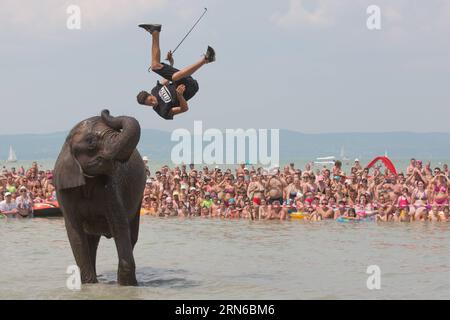 (150718) -- BALATONLELLE, 18. Juli 2015 -- die deutsche Rene Caselly Jr. springt vom Rücken eines Zirkuselefanten der Familie Caselly, während er am 18. Juli 2015 im Balaton-See in Balatonlelle, Ungarn, ein Bad nimmt. Zur Förderung der Circus Night führten die Familie Caselly und ihre Elefanten eine kurze Sonderschau am Strand von Balaton auf. UNGARN-BALATONLELLE-SOMMER-ZIRKUSELEFANT AttilaxVolgyi PUBLICATIONxNOTxINxCHN 150718. Juli 18 2015 Deutschland S René Jr springt vom Rücken eines Zirkuselefanten der Familie, während ER AM 18. Juli 2015 in der Förderung des Zirkus ein Bad im Balaton nimmt Stockfoto