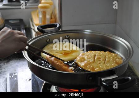 Eine muslimische Familie im Dorf Najiahu stellt traditionelle frittierte Snacks aus Öl her und feiert das Eid al-Fitr-Festival, das das Ende des islamischen heiligen Monats Ramadan in Yongning County von Yinchuan, der Hauptstadt der nordwestchinesischen Autonomen Region Ningxia Hui, am 17. Juli 2015 markiert. Das Dorf Najiahu ist ein Dorf mit 5.200 Einwohnern, von denen über 98 Prozent Hui-Muslime sind. (hgh) CHINA-NINGXIA-YINCHUAN-EID AL-FITR SPECIAL SNACKS (CN) JinxZhengfei PUBLICATIONxNOTxINxCHN eine muslimische Familie im Dorf Najiahu stellt traditionelle ölgebratene Snacks her, um das Oath Al Fitr Festival zu feiern, das Marks Th Stockfoto