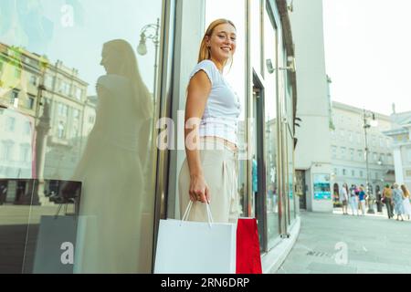 Eine junge Frau geht einkaufen und ist im Sommer glücklich Stockfoto