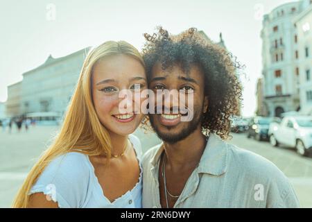 Porträt zweier junger Erwachsener unterschiedlicher ethnischer Herkunft, die im Sommer in der Stadt lächeln Stockfoto