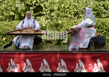 (150802) -- OBINITSA, 2. August 2015 -- Frauen in traditionellem Seto-Kostüm spielen traditionelles Seto-Instrument während der Seto-Königreichsfeier in Obinitsa, Estland, 2. August 2015. Das diesjährige Seto Kingdom feiert in Obinitsa, der finno-ugrischen Kulturhauptstadt 2015. Die ethnischen Gruppen der Seto aus Estland und dem westlichen Teil der russischen Oblast Pskow versammelten sich in Obinitsa, um an der Feier teilzunehmen und den diesjährigen König von Seto zu wählen, dessen Aufgabe es wäre, die Seto-Kultur zu schützen und zu fördern. ) (Djj) ESTLAND-OBINITSA-SETO VOLKSFEIER SergeixStepanov PUBLICATIONxNOTxINxCHN Stockfoto