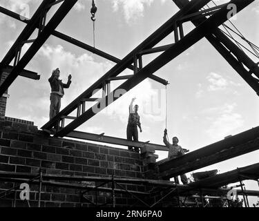 1950ER JAHRE MÄNNER BAUARBEITER INSTALLIEREN EISENBALKEN BAUEN NEUE FEUERWEHR BELLMAUR NEW JERSEY USA - I3007 HAR001 HARS VERTRAUEN B&W NORDAMERIKA NORDAMERIKA QUALIFIKATION BERUF FÄHIGKEITEN STÄRKE MUT KARRIEREN AUSSENWISSEN NIEDRIGER BLICKWINKEL FORTSCHRITT BESCHÄFTIGUNG NJ BERUFE KONZEPTIONELLE TRÄGER INFRASTRUKTUR NEW JERSEY MITARBEITER PRÄZISION SCHWARZ-WEISS HAR001 INSTALLATION DER ARBEIT ALTMODISCH Stockfoto