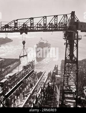 1940ER-JAHRE-ZUSCHAUERZAHL BEIM START EINES NEUEN MARINESCHIFFS WÄHREND DES 2. WELTKRIEGS AUF DER PHILADELPHIA NAVY WERFT USA - N316 HAR001 HARS SCHIFFE TRANSPORT FRACHT ZUSCHAUER B&W SAMMELN FREIHEIT HOCHWINKEL ABENTEUER STÄRKE MARINE SPANNUNG AUSSEN PA STARKE WELTKRIEGE WELTKRIEG 2 WELTKRIEG 2 WELTKRIEG II STREITKRÄFTE MARINEN 2. WELTKRIEG FRACHTER, DIE DIE SCHIFFSTAFFEL BESUCHEN SCHWARZ UND DIE WEISSE STADT DER BRÜDERLICHEN LIEBE HAR001 BRINGT EIN ALTMODISCHES SCHIFFBAUSCHIFF AUF DEN MARKT Stockfoto