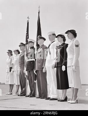 1950ER JAHRE MÄNNER FRAUEN IN DEN VERSCHIEDENEN UNIFORMEN DER US-ARMEE NAVY MARINES AIR FORCE MIT FLAGGEN STEHEND - M3781 HAR001 HARS NAVY HEALTHINESS UNITED STATES COPY SPACE FULL-LENGTH LADIES PERSONS INSPIRATION UNITED STATES OF AMERICA MÄNNER FORCE SELBSTVERTRAUEN B&W NORTH AMERICA FREEDOM NORTH AMERICAN 8 ADVENTURE PROTECTION LEADERSHIP LOW ANGLE PRIDE OPPORTUNITY MARINES BERUFE PATRIOT UNIFORMEN FARBE GUARD KONZEPTIONELLE PATRIOTISCHE STARS UND STREIFEN STILVOLLE UNTERSTÜTZUNG VERSCHIEDENE ZUSAMMENARBEIT ACHT PATRIOTISMUS ROT WEISS UND BLAU JUNGE ERWACHSENE MANN JUNG ERWACHSENE FRAU SCHWARZ-WEISS Stockfoto