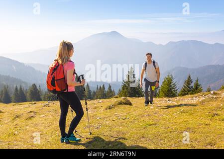 Ein Paar wandert an einem klaren, sonnigen Tag und genießt im Herbst die wunderschöne Bergwelt. Sport-, Erholungs- und gesunde Lebenskonzepte. Stockfoto