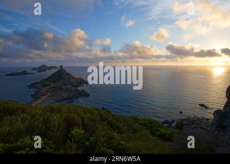 Sonnenuntergang über dem beliebten Touristenziel Torra di Parata mit genuesischem Turm und Inselgruppe Sanguinaires im Hintergrund. Stockfoto