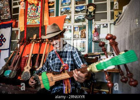 (150810) -- LHASA, - der 46-jährige Handwerker Dainzin spielt in Lhasa, der Hauptstadt der autonomen Region Tibet im Südwesten Chinas, das tibetische Instrument Dramyin, 9. August 2015. Dramyin, ein sechssaitiges Musikinstrument, ist ein altes tibetisches Zupfinstrument. Es handelt sich um eine langärmelige, doppelt taillierte und fretless Laute. Sie ist in der Regel aus einem Stück Holz ausgehöhlt und kann von 60 bis 120 Zentimeter lang sein. Im Jahr 2014 wurde die Herstellung von Draymin als eines der nationalen immateriellen Kulturerben Chinas registriert. ) (zhs/lfj) CHINA-LHASA-TIBETISCHES INSTRUMENT DRAMYIN (CN) ZhengxHuansong ÖFFENTLICH Stockfoto